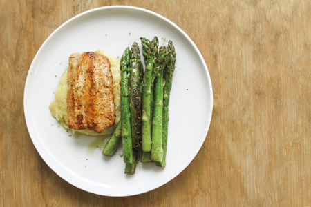 Seasoned roasted green asparagus with grilled salmon on polentaの写真素材