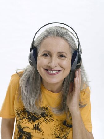 Senior woman wearing headphones, portraitの写真素材