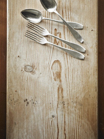 Forks and spoons on woodの写真素材