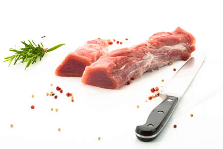 Pork loin and herbs, knife, white backgroundの写真素材