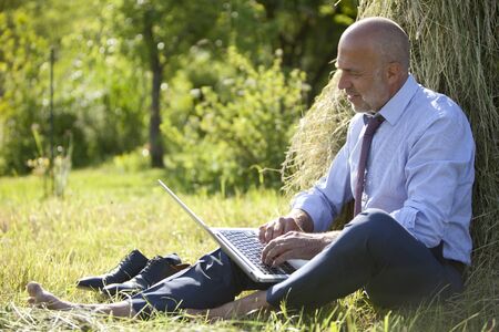 Germany, Bavaria, businessman working with laptop outdoorの写真素材