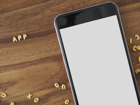 Smartphone on wood with alphabet noodlesの写真素材
