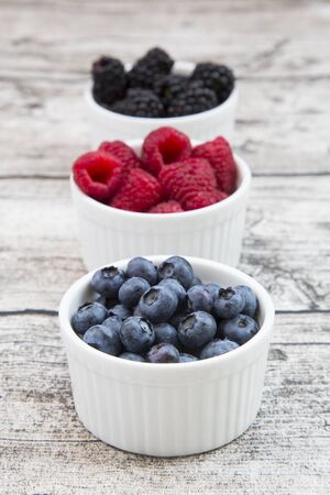 Wild berries, Raspberries, blueberries and blackberries in bowlsの写真素材