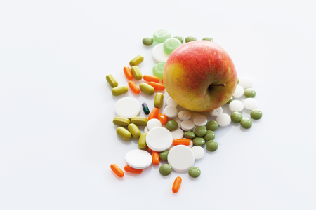 Apple with tablets on white の写真素材