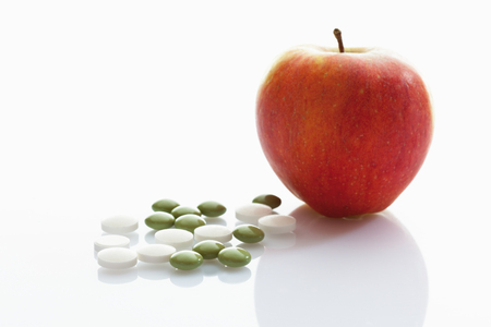 Apple with tablets on white の写真素材