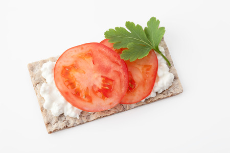 Crispbread with tomato slice,parsley and cream cheeseの写真素材