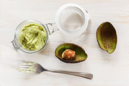 Avocado cream, preserving jar on chopping board