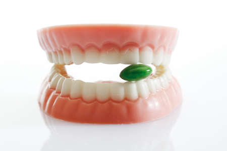 Dentures made of sugar and white chocolate with tablet on white background,close upの写真素材