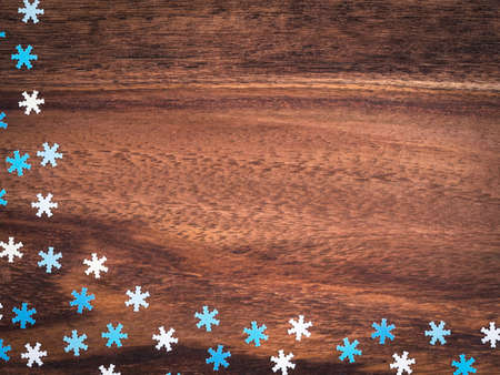 Christmas, blue and white paper snowflakes on wood, copy spaceの写真素材