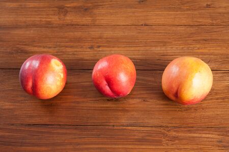 Row of nectarines on woodの写真素材