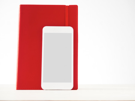 Smartphone and red notebook, analogue, digital, information storageの写真素材