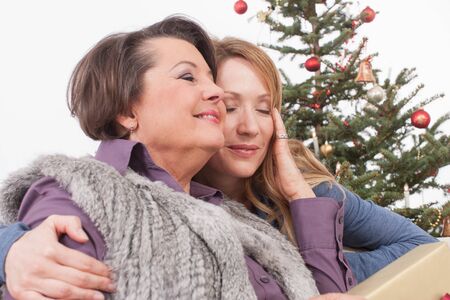 Senior woman and adult woman smiling with Christmas giftの写真素材