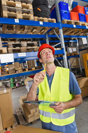 Germany,Bavaria,Munich,Manual worker with clipboard in warehouseの写真素材