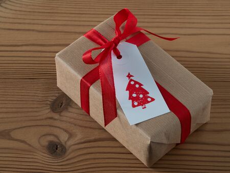 Christmas present with gift tag, printed, red ribbonの写真素材