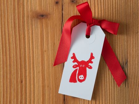 Christmas, gift tag, printed, red ribbon, background woodの写真素材