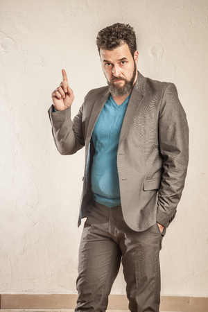 Business man with beard raising fingerの写真素材