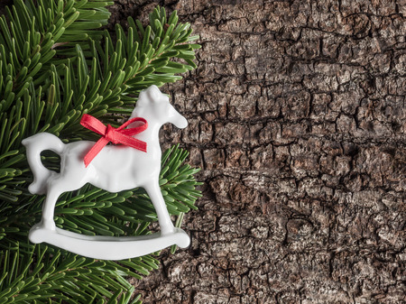 Christmas decoration on bark, evergreens, rocking horseの写真素材