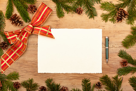 Blank card, ballpen, fir twigs and ribbon, on woodの写真素材