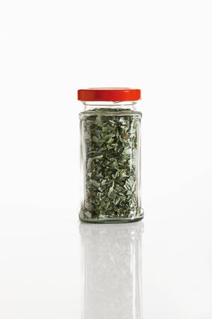 Basil in glass jar on white backgroundの写真素材