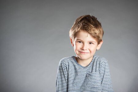 Portrait of boy, emotion, smiling, grey backgroundの写真素材