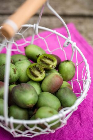 Kiwi berries in basket on woodの写真素材