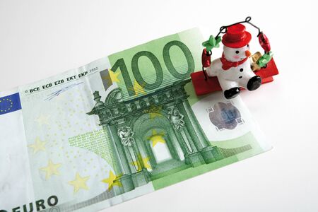 Snowman sitting on Euro notes, elevated viewの写真素材