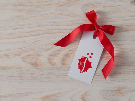 Christmas, gift tag, printed, red ribbon, background woodの写真素材