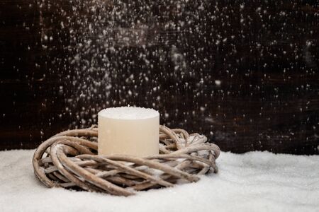 Christmas decoration, wreath with candle, artificial snow and falling snowの写真素材
