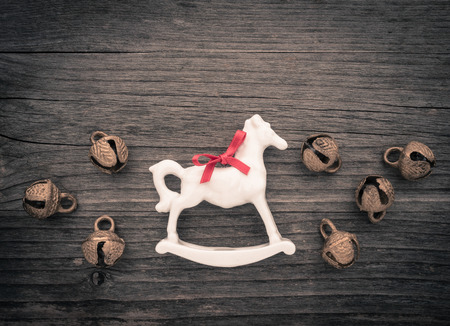 Christmas decoration, rocking horse and bells on woodの写真素材