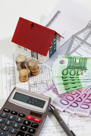 Model house calculator euro notes and coins on blueprint, planning constructionの写真素材