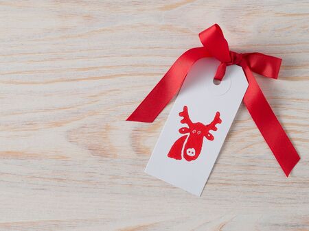 Christmas, gift tag, printed, red ribbon, background woodの写真素材