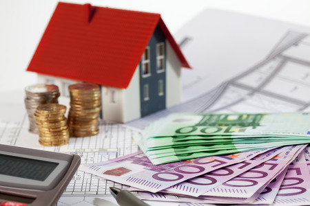Model house calculator euro notes and coins on blueprint, planning constructionの写真素材