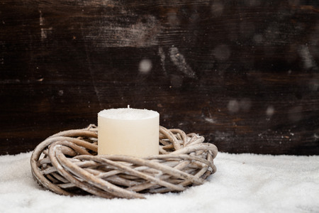 Christmas decoration, wreath with candle, artificial snow and falling snowの写真素材