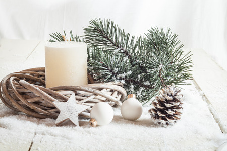 Christmas decoration, candle, artificial snow, twigs, cone, baubles and starの写真素材