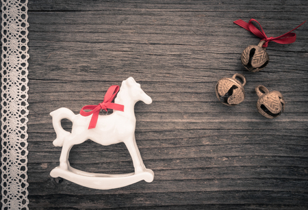 Christmas decoration, rocking horse, lace and bells on woodの写真素材