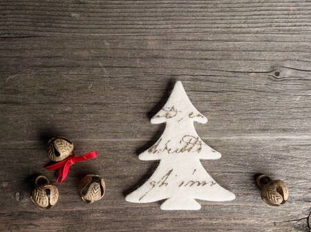 Christmas decoration of felt, christmas tree, bells on woodの写真素材