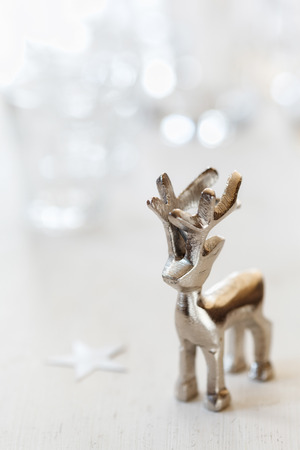 Reindeer figurine on white wooden backgroundの写真素材