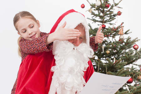 Girl covering eyes of Santa Clausの写真素材