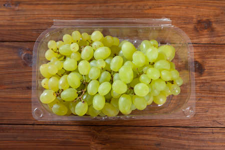 Plastic bowl with green grapesの写真素材