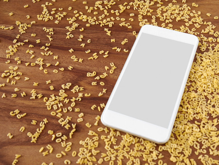 Smartphone on wood, alphabet noodles, app, cooking appの写真素材