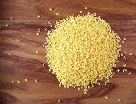 Alphabet noodles on woodの写真素材