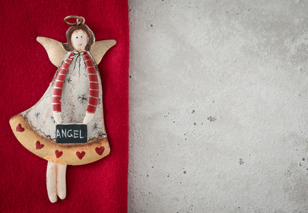 Christmas decoration, angel on red loden, concrete, copy spaceの写真素材