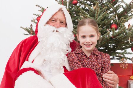 Girl sitting with Santa Claus, smilingの写真素材