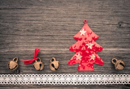 Christmas decoration of metal, christmas tree, bells on woodの写真素材