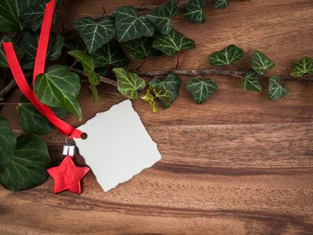 Christmas, ivy, christmas decoration star, gift tag on woodの写真素材