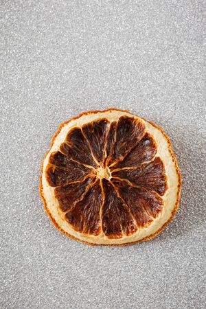 Dried orange slice on silver shiny undergroundの写真素材