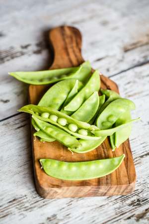 Snow peas on chopping boardの写真素材