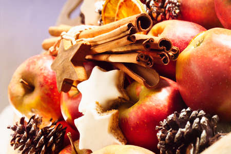 Christmas plate, apples, cinnamon stars, fir cones and cinnamon sticksの写真素材