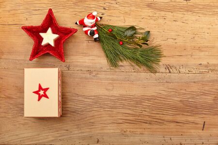 Christmas present, fir twig and Santa Claus figurine on woodの写真素材