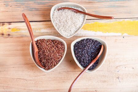 Red, black and white rice in bowlsの写真素材